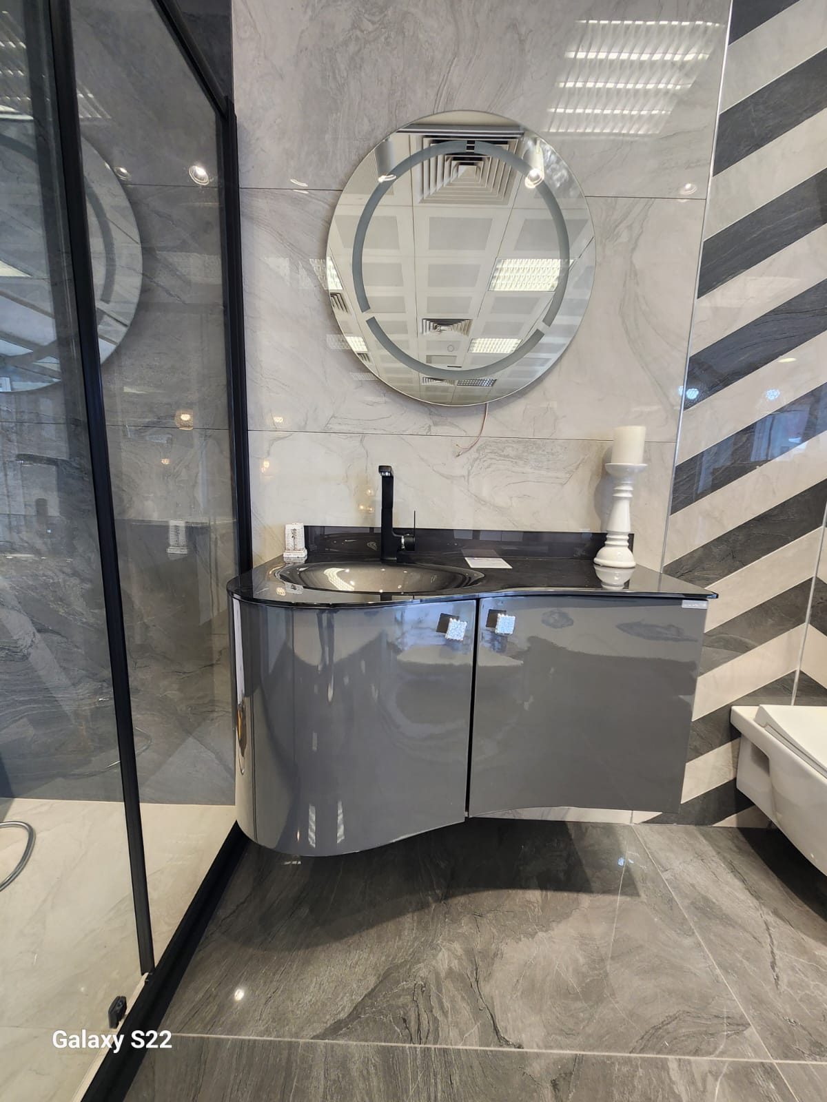 Gri parlak banyo dolabı ve yuvarlak ayna